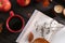 Cup of hot drink, book and ripe apples on wooden table, flat lay. Cozy autumn atmosphere