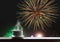 Cup of hot drinks on wooden desk with celebrate fireworks on night sky