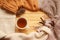Cup of hot fragrant tea on a wooden background, autumn leaves, apple, cozy scarves and knitted sweaters, flat, concept hugge,