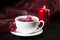 Cup of hot karkade tea on the plate with hibiscus flower and red cloth on the background. Herbal tea concept. Hot drink