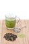 Cup of hot milk green tea, measuring spoon, green tea powder and