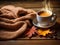A cup of hot steaming coffee with a scarf and Autumn maple tree leaf on wooden table. Autumn seasonal concept.