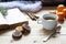 Cup of hot tea with books, cookies and tangerines on light wooden table.