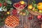 Cup of hot tea and dessert on an autumn wooden table with vegetables and fruits on a wooden table with leaves, flat lay, top view