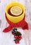 Cup of hot tea with lemon wrapped woolen scarf and cotoneaster, warming beverage for flu