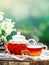 Cup with hot tea with mint and a thyme on a wooden table in a summer garden. Selective focus,