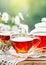 Cup with hot tea with mint and a thyme on a wooden table in a summer garden. Selective focus,