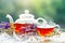 Cup with hot tea with mint and a thyme on a wooden table in a summer garden. Selective focus,