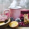 A cup of hot tea stands on a wooden table next to a wooden plate on which are gingerbread cookies made from orange slices against