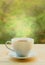 Cup of Hot Tea on Wooden Table against Green Foliage in Artistic Stained Glass Style