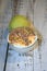 A cup of ice cream with a scattering, a green apple and a flooring lie on a wooden table. Still life. Close-up