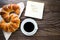 A cup of instant coffee with a croissant and message have a good time on the textured wooden background top view, cozy and