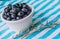 A Cup Of Juicy Blueberries At A Bright Blue Stripy Background