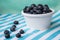 A Cup Of Juicy Blueberries At A Bright Blue Stripy Background