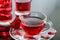 Cup of magenta hibiscus tea (rosella, karkade) on table