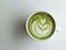 A cup of matcha latte art on white background