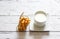 Cup of milk and breadsticks tied with string on a wooden background. Healthy snack.