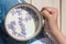 Cup with milk and small purple lilac flowers with hand