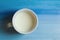 Cup of milk stay on wooden painted tray close up photo woth copyspace