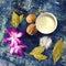 Cup of milk with walnuts salt bay leaves and flower purple petals  on blue rugged background