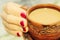 A cup of morning aromatic coffee in the hands with manicure