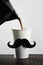 Cup with a moustache being filled with coffee