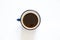 a cup with overturned coffee on a white background and a teaspoon lies next to it