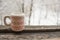 Cup with a pattern on a wooden window sill in winter