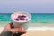 A cup of red bean sweet with red ice in hand at the beach