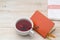 Cup of red tea and orange notepad