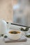 Cup of sage tea and green leaves on white wooden windowsill