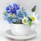 Cup and saucer with bunch of wild flowers