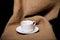 Cup and saucer on a burlap a black background. Toned