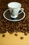 Cup with saucer on coffee beans background