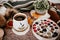 Cup of strong black coffee, autumn leaves and handmade woolen socks on wooden background