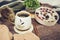 Cup of strong black coffee, autumn leaves and handmade woolen socks on wooden background