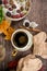 Cup of strong black coffee, autumn leaves and handmade woolen socks on wooden background