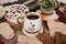 Cup of strong black coffee, autumn leaves and handmade woolen socks on wooden background