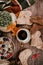 Cup of strong black coffee, autumn leaves and handmade woolen socks on wooden background