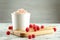 Cup with tasty frozen yogurt and raspberries on marble table