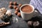 Cup of tasty hot chocolate and sweets on dark background