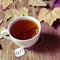 A cup with a tea bag with the word fall in its label