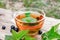 A cup of tea with black currant leaves. Tea with currants on a wooden table in the open air