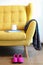 Cup of tea and blue book on a yellow coach. Still life details in home interior of living room. Cozy home interior, home comfort