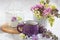 a cup of tea and a branch of lilac on a white background in a basket.