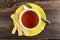 Cup of tea, breadsticks with filling, spoon on saucer on wooden table. Top view