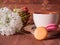 Cup with tea, cakes on the table and white flowers on the background