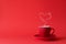Cup of tea or coffee with steam in one heart shape on red background. Valentine`s day celebration or love concept. Copy space