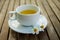 Cup of tea & Couple of wild daisy flower on a ceramic dish on wooden table