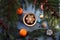 A Cup of tea with a decorative snowflake, tangerines, juniper branches, blue background, top view-the concept of pleasant winter